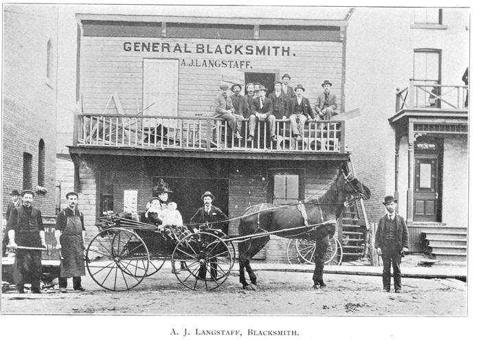 Black and white framed vintage photo of horse drawn cart and people standing in front of store front reading General Blacksmith