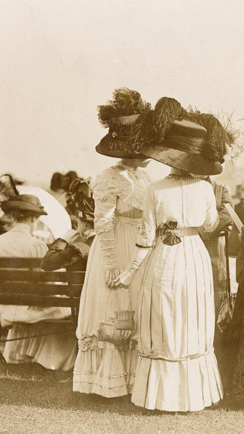 Vintage photo of women in fancy attire spectating outside Vintage photo of women in fancy attire spectating outside