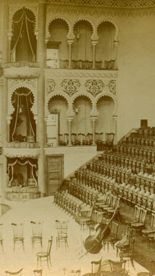 Inside ornate vintage building with instruments on stage and empty chairs Inside ornate vintage building with instruments on stage and empty chairs