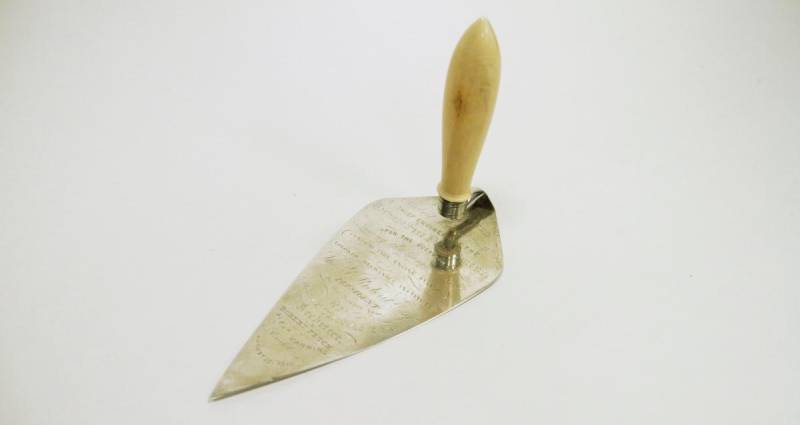 Trowel with lots of engravings and a wooden handle