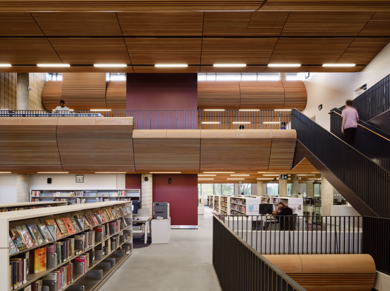 Interior view of Albert Campbell District branch taken on the first floor with book shelves, and a view of the staircase leading to the open concept second floor. Interior view of Albert Campbell District branch taken on the first floor with book shelves, and a view of the staircase leading to the open concept second floor.