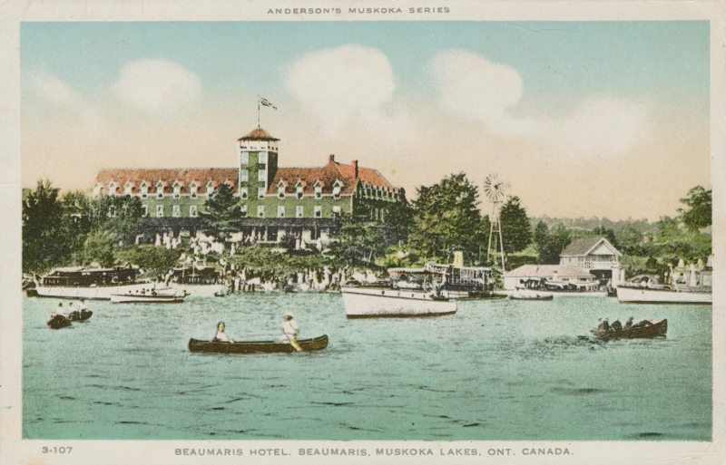 Vintage postcard of lake with canoes and people on shore and large hotel in the forest as well as border of text indicating the location