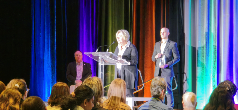 Person in the spotlight on stage, speaking at the podium, giving a speech in front of an audience Person in the spotlight on stage, speaking at the podium, giving a speech in front of an audience