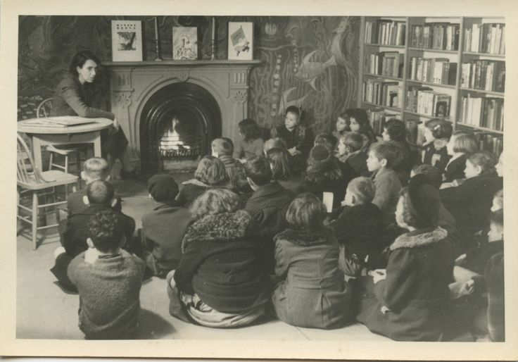 Circa 1940s Boys and Girls House storytime.  Children's librarian reading to a group.