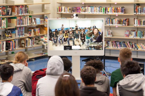 Children using Cisco's telepresence technology to connect with another classroom
