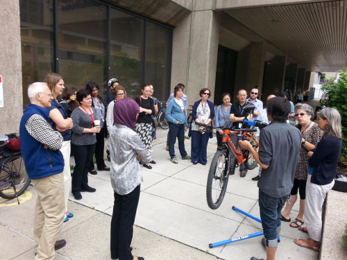 A crowd gathers for a bike workshop demo A crowd gathers for a bike workshop demo