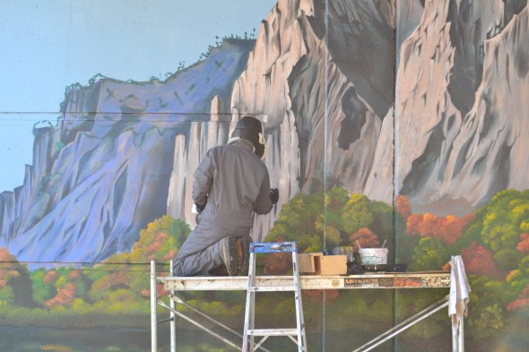 Artist Andrew Horne painting underpass mural