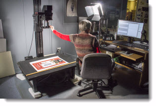 Staff digitizing a large poster with high resolution overhead scanner Staff digitizing a large poster with high resolution overhead scanner