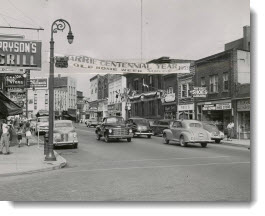 Bright colored banners stretching across main street tell of centennial celebrations, Barrie, Ontario