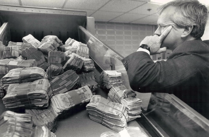 Doomed dollars: The Bank of Canada used to burn old bills that were too scruffy to be recirculated. Today; the millions are shredded into specks of paper by this machine; under the watchful eye of Ross Tousaw; Toronto agent and banking operations adviser for the central bank.