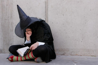 Girl reading Harry Potter wearing a witch's hat