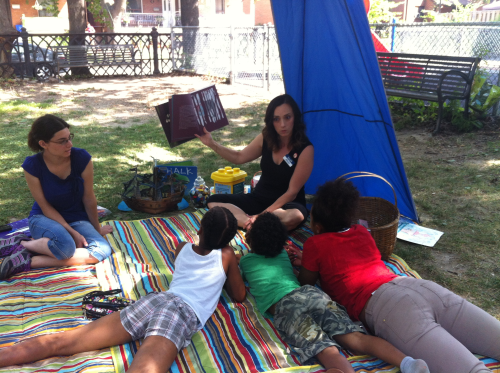 TPL staff reading to kids in the park
