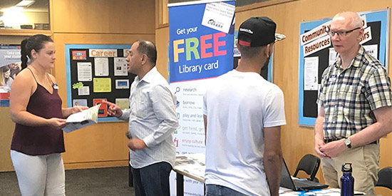Library staff talk to business college students