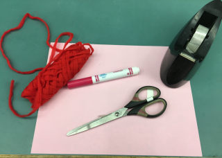 Craft supplies including string, paper, marker, scissors, and tape.