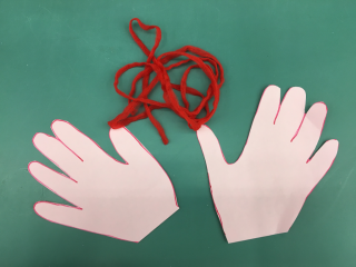 Hands cut out of paper and a length of string.