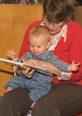 Adult and small child reading together. Adult and small child reading together.