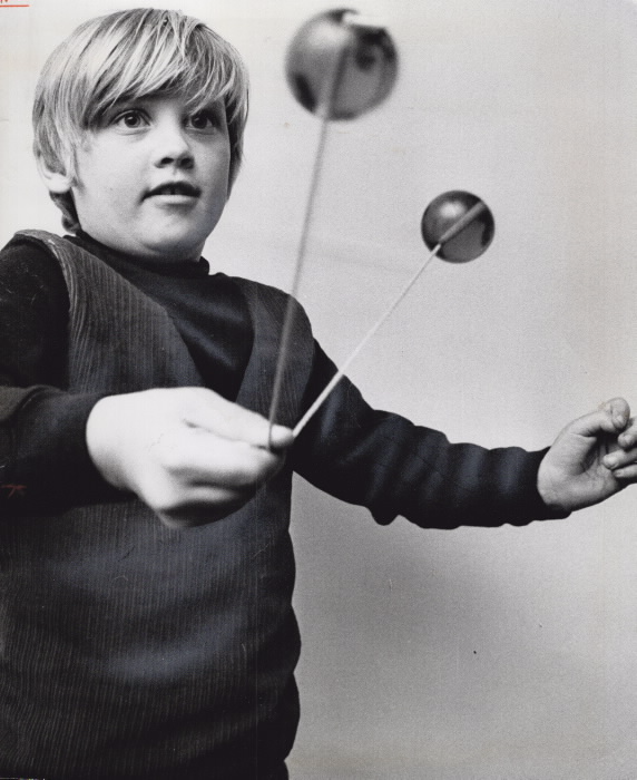 Boy plays with a toy that consists of two balls attached by string