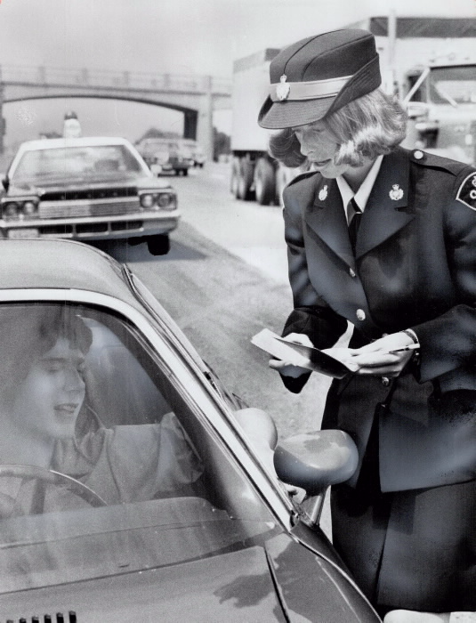 Cathy Dekking doing police business on the street  talking to a man in a car
