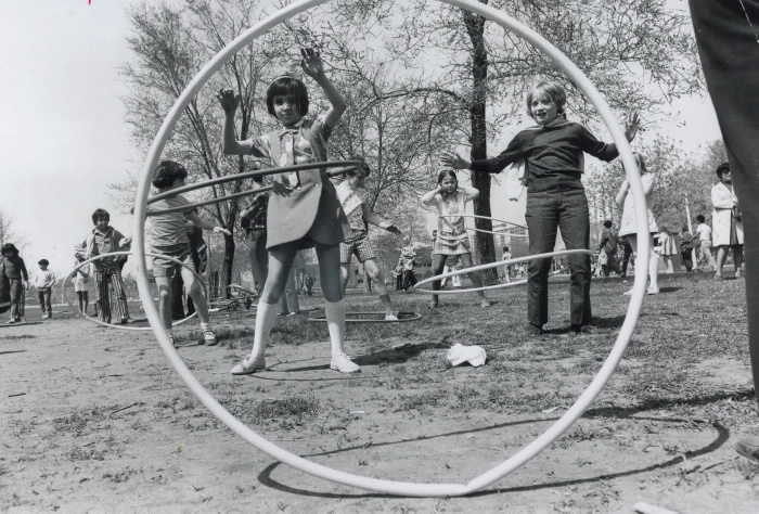 Children using hula hoops in a park