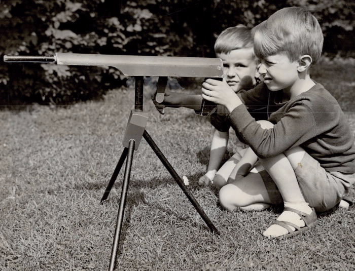 Two boys playing with a toy machine-gun