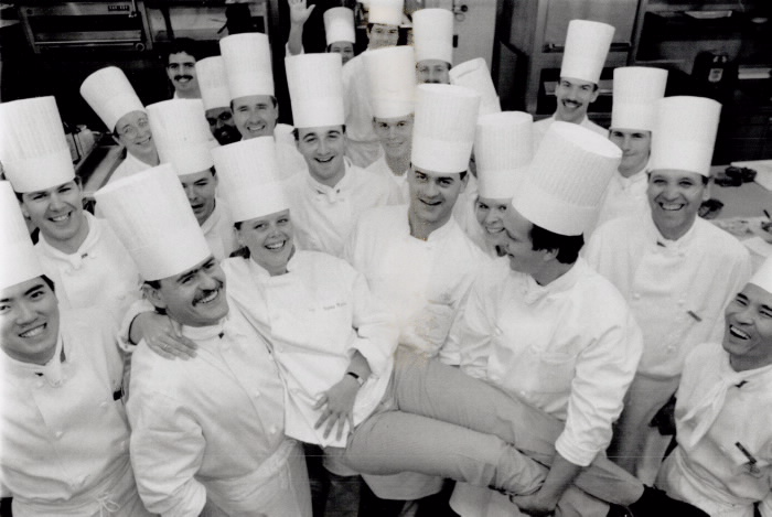 Susan Weaver being held up be other staff  all with chef hats