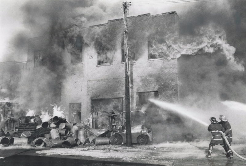 Two fire fighters spray into a burning building Two fire fighters spray into a burning building