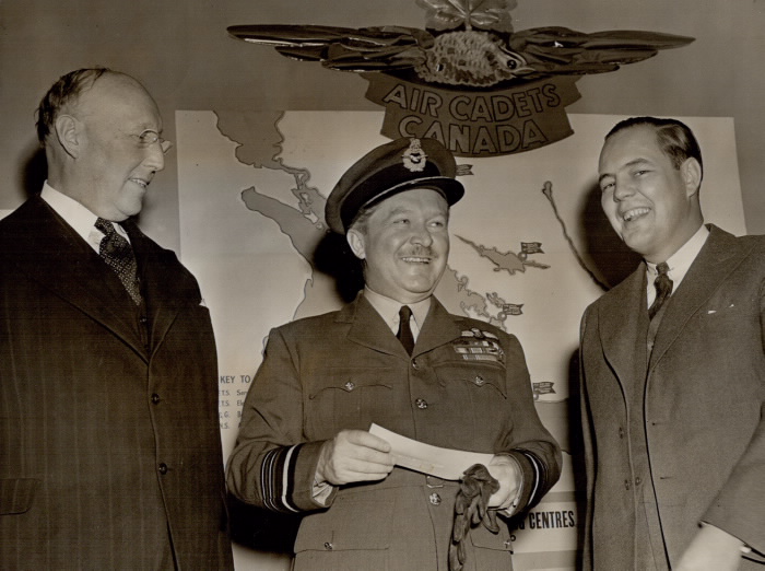 Billy Bishop standing beside two men in front of map