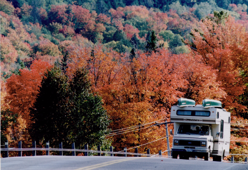 Big camper with two canoes with a gorgeous Algonquin autumn backdrop