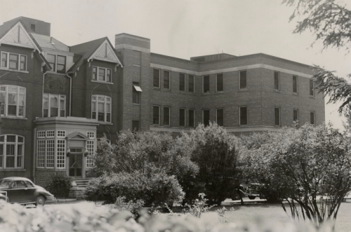 Large brick building with trees in front