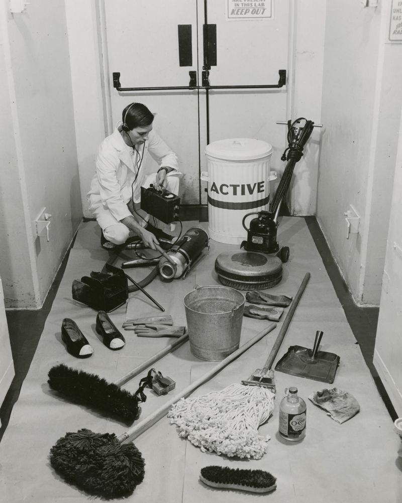 Man using a Geiger counter to measure radioactivity of various items