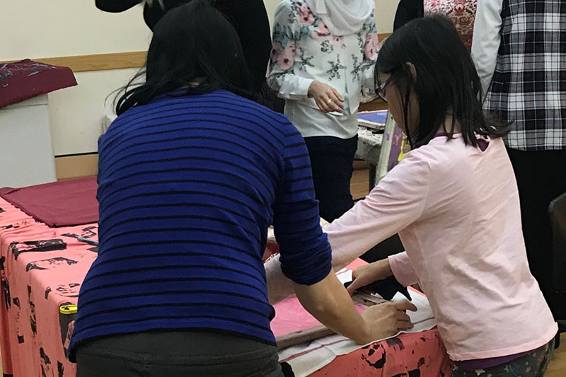 Participants work on silk screening
