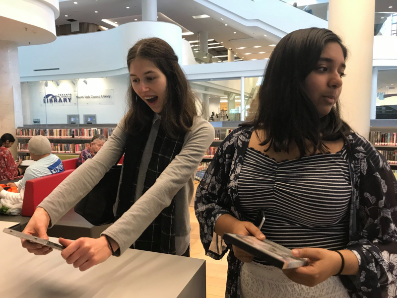 Teens look happy at finding a DVD Teens look happy at finding a DVD